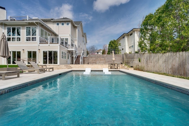view of swimming pool featuring a fenced backyard, stairway, and a patio area