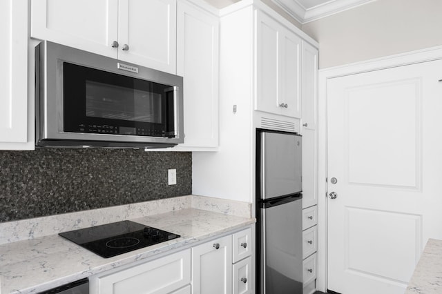 kitchen with stainless steel appliances, white cabinets, crown molding, backsplash, and light stone countertops