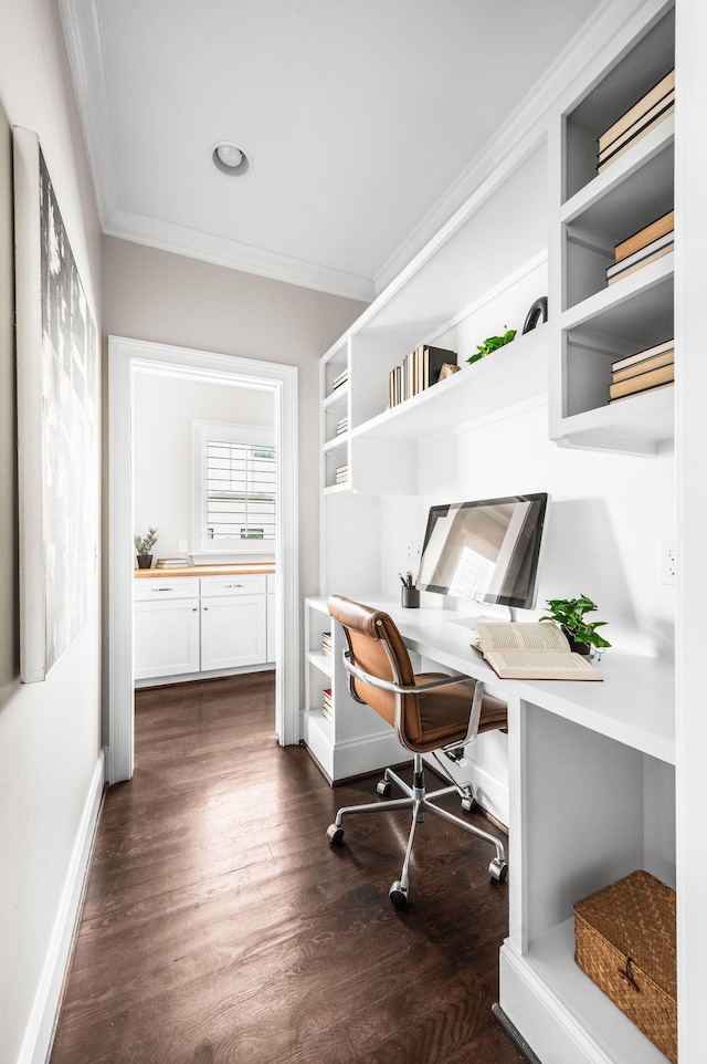 home office with ornamental molding, dark wood-type flooring, built in study area, and baseboards