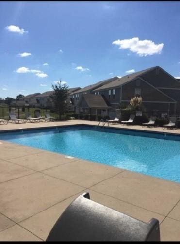 community pool featuring fence and a patio
