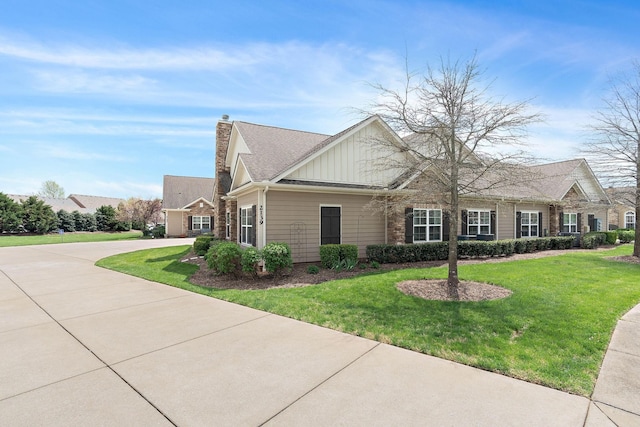 2139 Stonecenter Ln, Murfreesboro, TN 37128 - view of front facade featuring board and batten siding, a front yard, a chimney, and concrete driveway