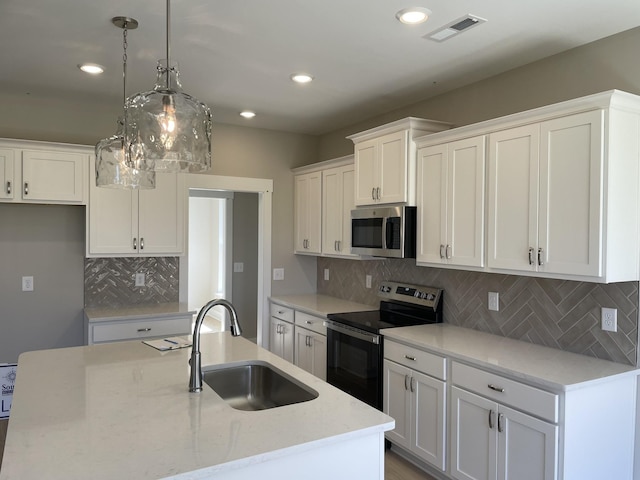 121 Lightberry Ln, Hendersonville, TN 37075 - kitchen featuring appliances with stainless steel finishes, a sink, white cabinetry, decorative backsplash, and pendant lighting