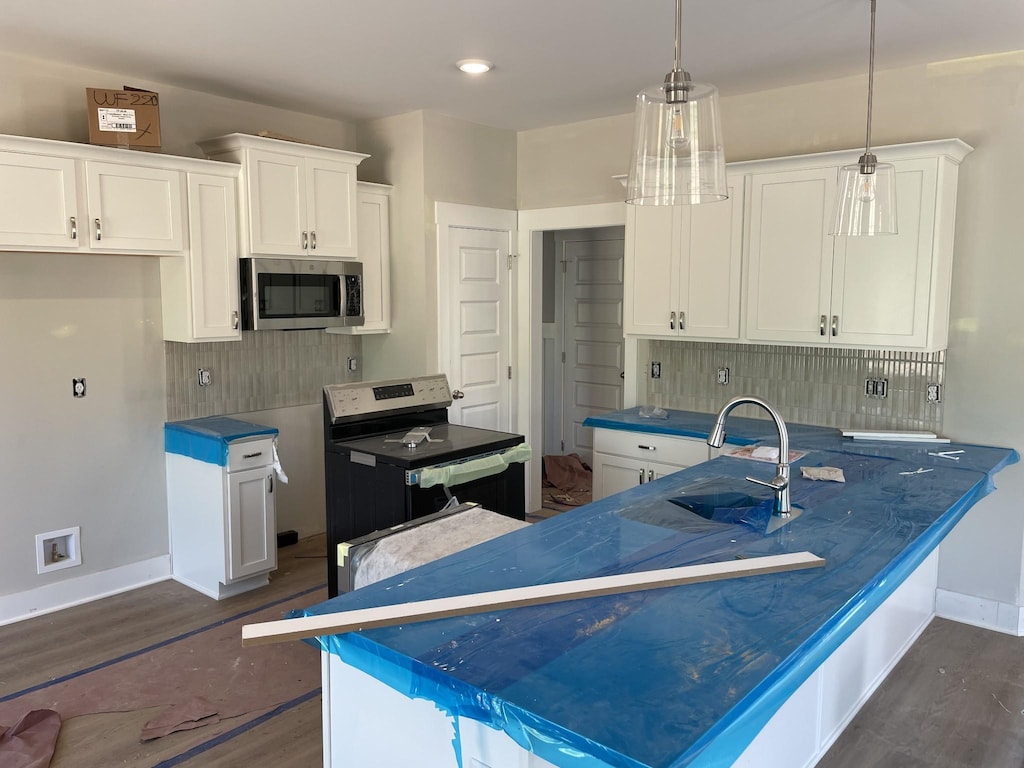112 Hayden Ln, Gallatin, TN 37066 - kitchen with appliances with stainless steel finishes, dark wood finished floors, a sink, white cabinets, and tasteful backsplash