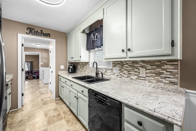 kitchen featuring black dishwasher, a sink, decorative backsplash, a textured ceiling, and light stone counters