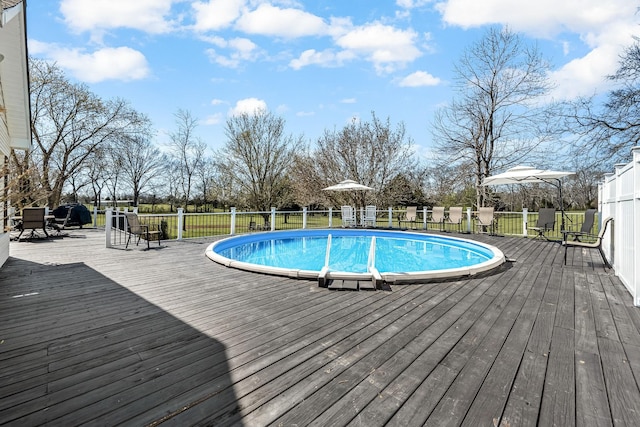 view of swimming pool with a deck and fence