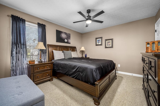 bedroom featuring light carpet, a textured ceiling, baseboards, and a ceiling fan