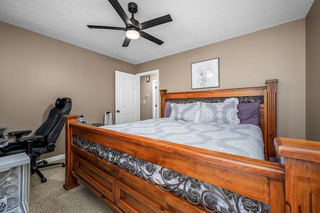 carpeted bedroom with a textured ceiling, baseboards, ceiling fan, and a desk
