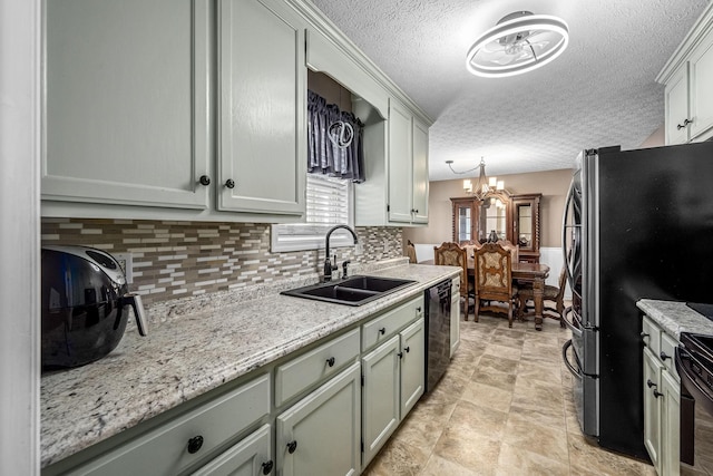 kitchen featuring a sink, black dishwasher, a textured ceiling, a chandelier, and decorative backsplash