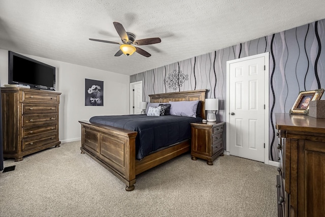 bedroom with a textured ceiling, light colored carpet, a ceiling fan, and baseboards