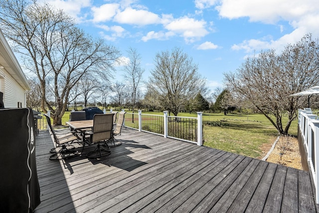wooden deck with outdoor dining area and a lawn