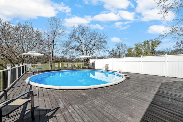 view of pool featuring a deck and fence