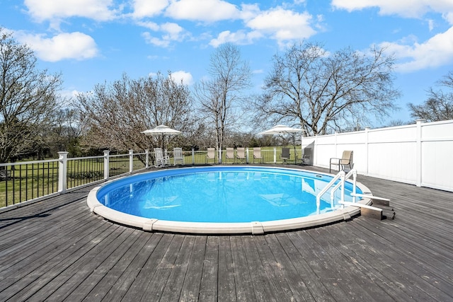 view of pool with a deck and fence