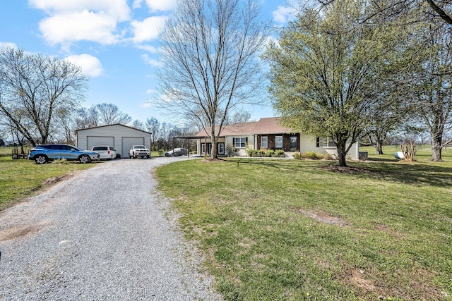 ranch-style house featuring a detached garage, a front yard, and gravel driveway
