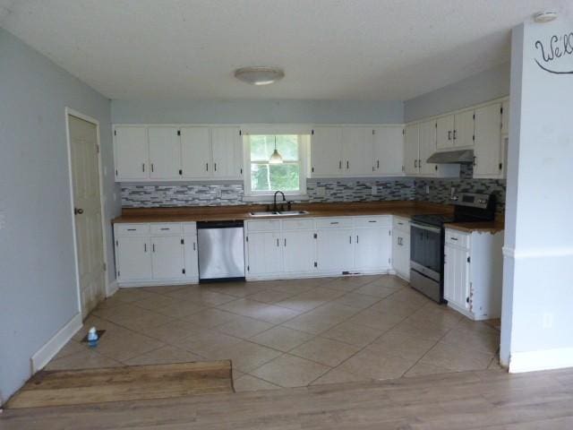114 Bruce St, Huntland, TN 37345 - kitchen with stainless steel appliances, under cabinet range hood, a sink, backsplash, and white cabinets