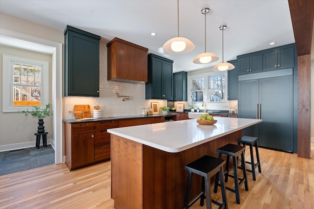 1908 Beechwood Ave, Nashville, TN 37212 - kitchen featuring light wood finished floors, backsplash, a breakfast bar area, built in fridge, and recessed lighting