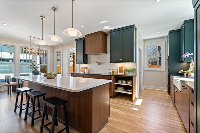 1908 Beechwood Ave, Nashville, TN 37212 - kitchen featuring baseboards, light wood-type flooring, decorative backsplash, a center island, and a breakfast bar area