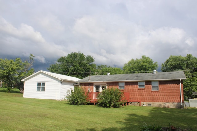 rear view of property with a yard, brick siding, and a deck