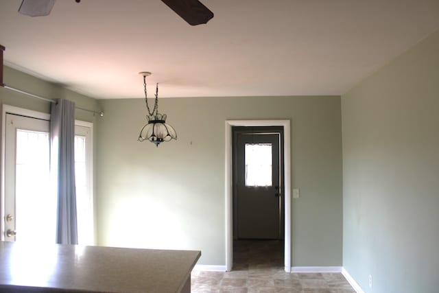 dining space featuring ceiling fan and baseboards