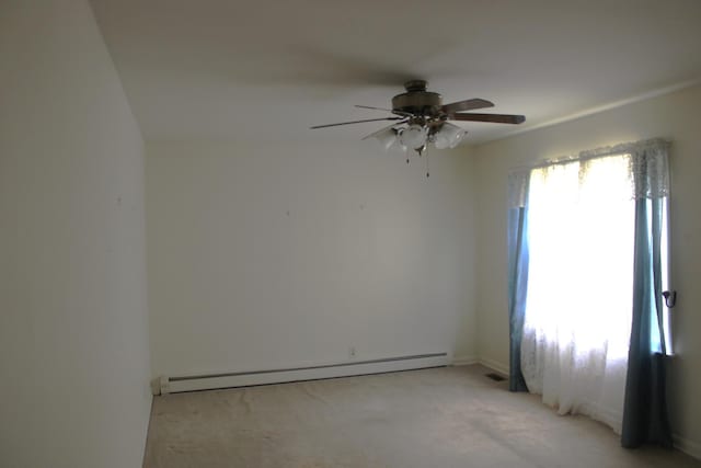 empty room featuring a baseboard heating unit, a ceiling fan, and light carpet