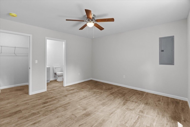 674 Eber Rd, Dalton, GA 30720 - unfurnished bedroom with electric panel, a walk in closet, a closet, light wood-style flooring, and baseboards