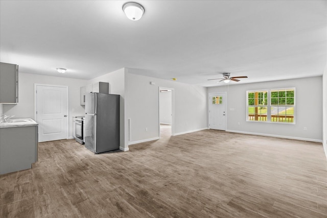 674 Eber Rd, Dalton, GA 30720 - unfurnished living room with a ceiling fan, baseboards, a sink, and light wood-style floors