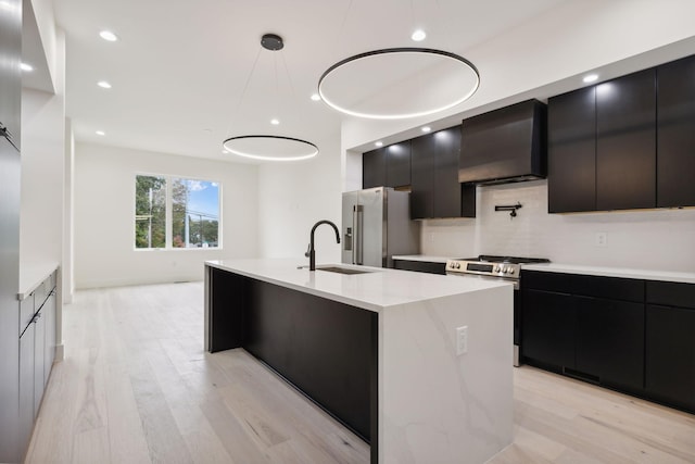 kitchen with range hood, stainless steel appliances, modern cabinets, a sink, and dark cabinets