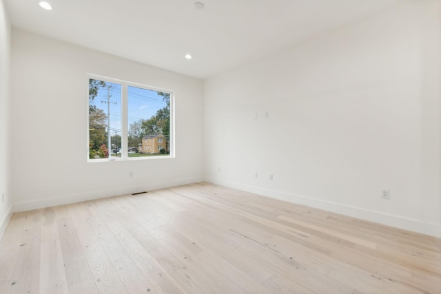 empty room featuring recessed lighting, light wood-type flooring, and baseboards