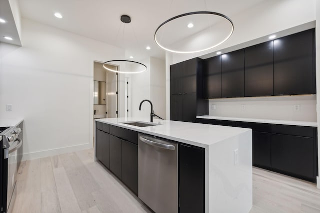 kitchen with modern cabinets, stainless steel appliances, a sink, dark cabinetry, and recessed lighting