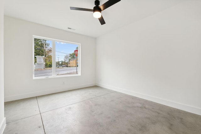 spare room with baseboards, ceiling fan, and concrete flooring