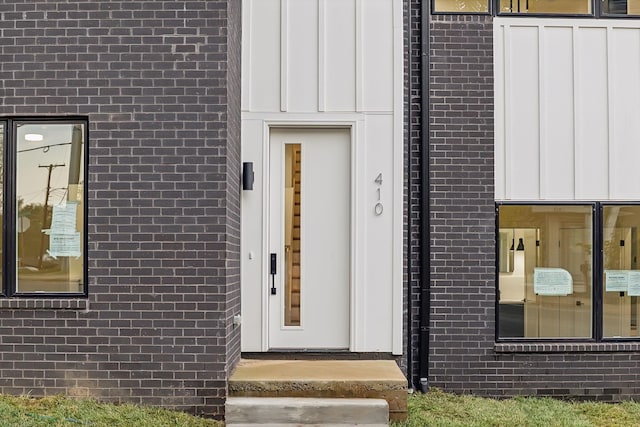 entrance to property with brick siding and board and batten siding