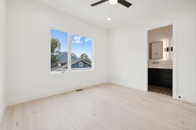 unfurnished bedroom with light wood finished floors, baseboards, ensuite bathroom, recessed lighting, and a ceiling fan