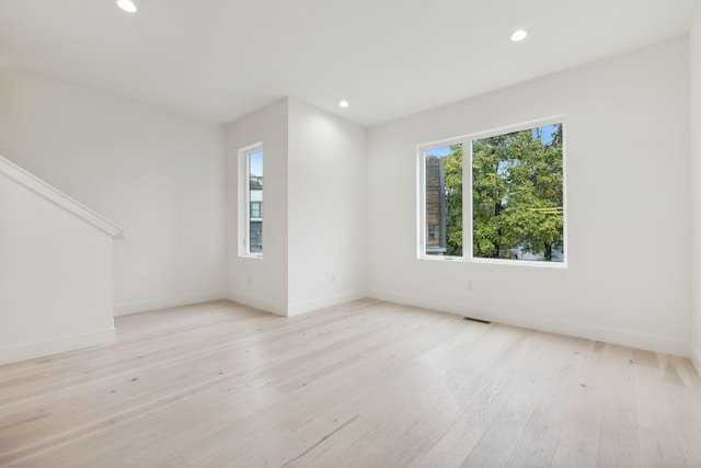 spare room with light wood-style floors, recessed lighting, and baseboards