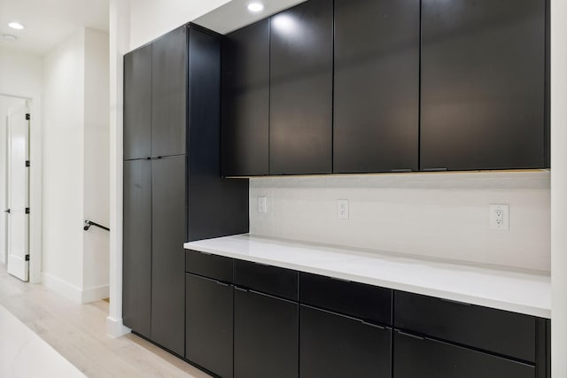 kitchen with modern cabinets, dark cabinets, light countertops, and recessed lighting