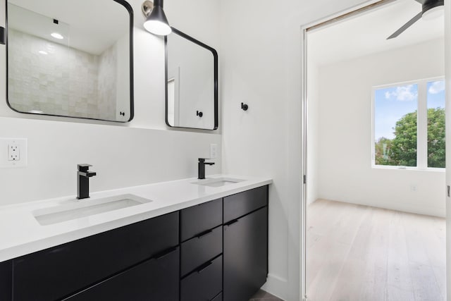 bathroom with ceiling fan, wood finished floors, and double vanity