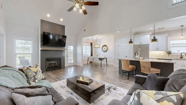 788 Jersey Dr, Clarksville, TN 37043 - living area featuring high vaulted ceiling, a ceiling fan, light wood-style flooring, a large fireplace, and recessed lighting