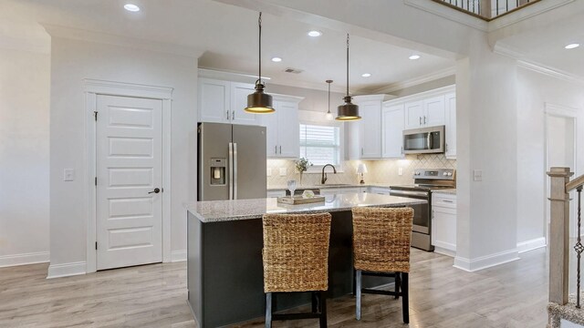 788 Jersey Dr, Clarksville, TN 37043 - kitchen featuring stainless steel appliances, a sink, light wood-type flooring, a kitchen island, and crown molding