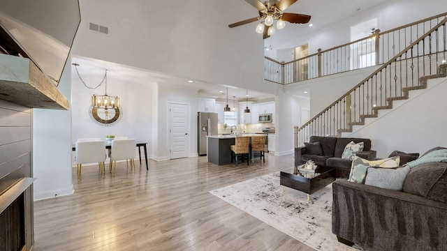 788 Jersey Dr, Clarksville, TN 37043 - living area featuring a high ceiling, stairway, ceiling fan, light wood-style floors, and a chandelier