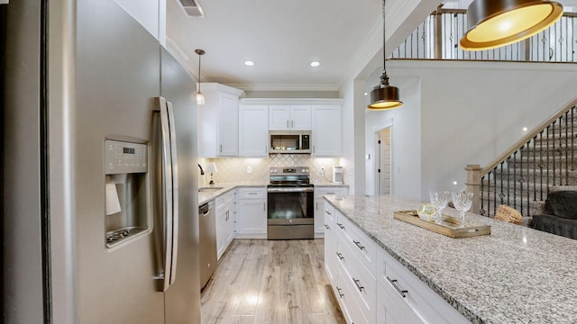 788 Jersey Dr, Clarksville, TN 37043 - kitchen with appliances with stainless steel finishes, crown molding, light stone counters, white cabinets, and tasteful backsplash