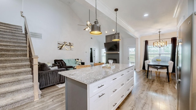 788 Jersey Dr, Clarksville, TN 37043 - kitchen with stainless steel fridge, a chandelier, crown molding, light stone counters, and white cabinets