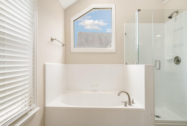 bathroom with a stall shower and a garden tub