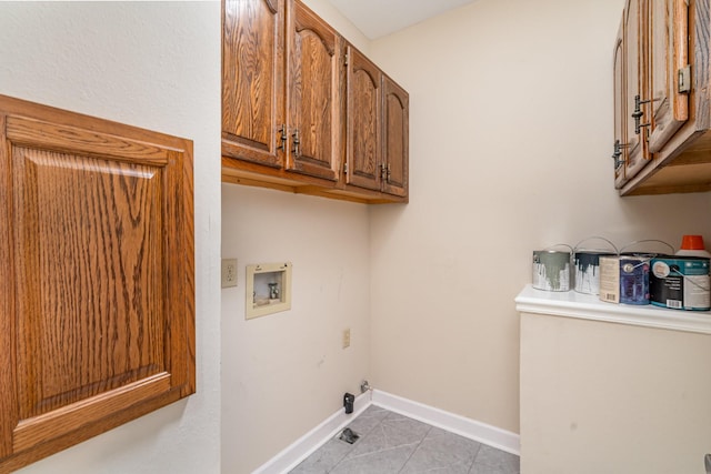 washroom with washer hookup, cabinet space, light tile patterned floors, and baseboards