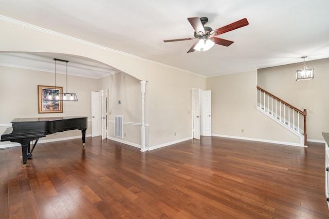 unfurnished living room with wood finished floors, a ceiling fan, stairs, arched walkways, and baseboards