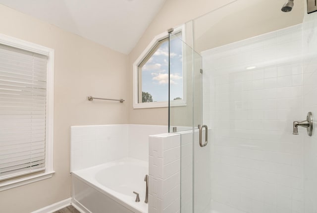 bathroom featuring a garden tub, a stall shower, and vaulted ceiling
