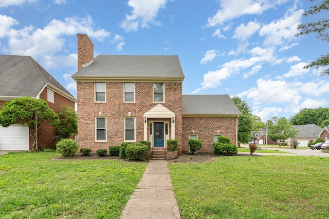 view of front of property with brick siding, a front yard, a chimney, and roof with shingles