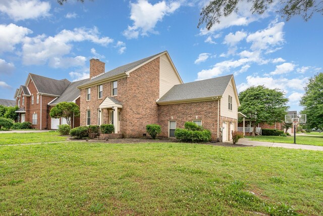 view of front facade featuring brick siding, concrete driveway, a garage, and a front yard