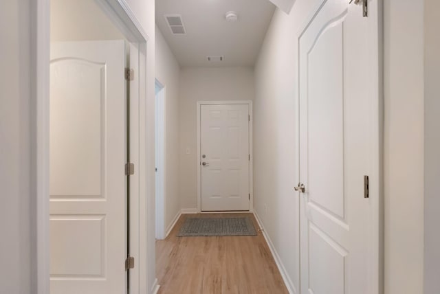 hallway featuring light wood-style floors and baseboards