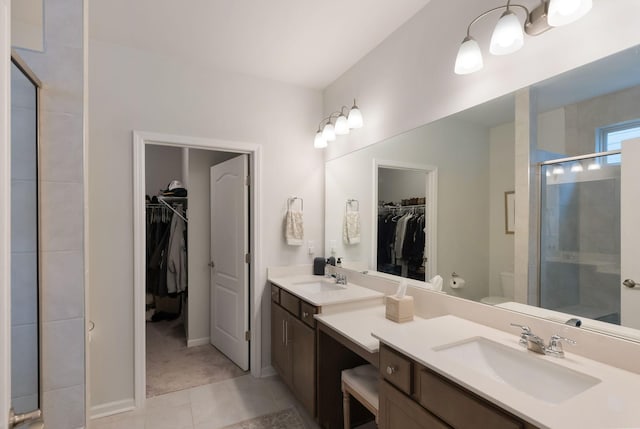 full bath with a shower stall, tile patterned flooring, toilet, double vanity, and baseboards