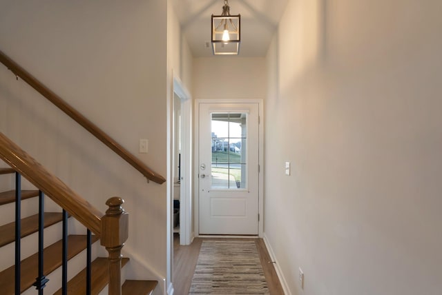 doorway to outside with stairs, wood finished floors, and baseboards