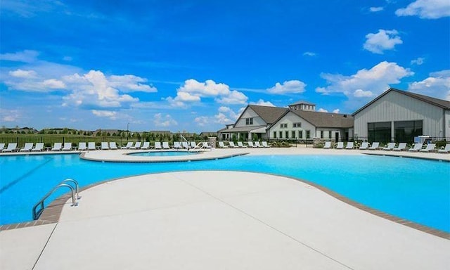 community pool with fence, a jacuzzi, and a patio