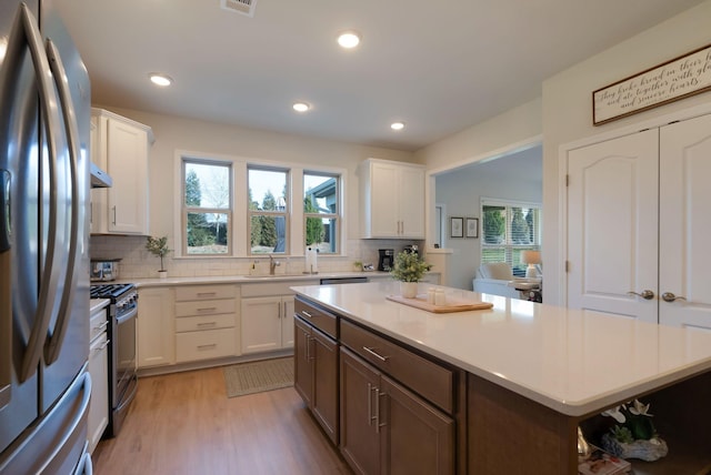 kitchen with appliances with stainless steel finishes, plenty of natural light, decorative backsplash, and recessed lighting